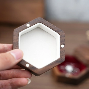 Close-up of hexagonal black walnut jewelry box lid with white velvet and magnetic closure