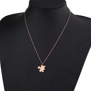 Vue détaillée du pendentif puzzle en or rose présenté sur un buste de mannequin noir