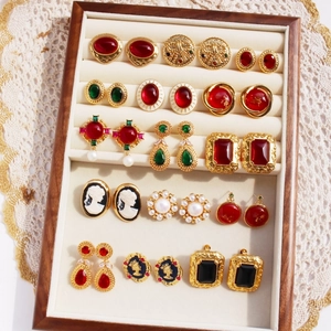 Assorted vintage style earrings with pearls and emerald green stones in a wooden box