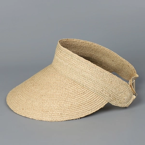 Detail view of woven raffia sun visor featuring an adjustable metal buckle and elastic strap