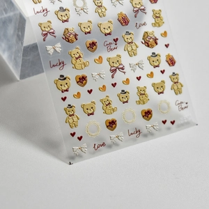 Close-up of embossed 3D cute bear nail art stickers with heart and ribbon patterns