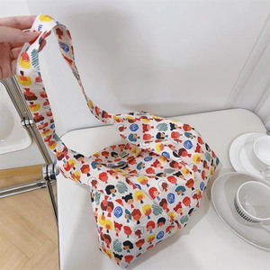 Close-up of a large cotton tote bag featuring colorful cartoon character prints and wide straps