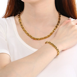 Polished gold stainless steel square chain necklace and bracelet set on a model