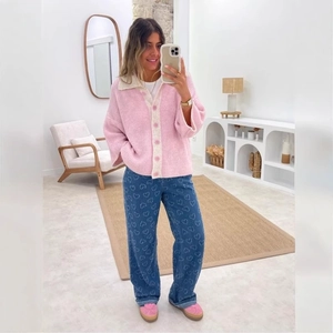 Pink knit cardigan and blue straight-leg jeans with heart patterns on a female model