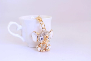 Close-up of golden elephant keychain with sparkling rhinestones and white enamel ear