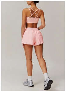 Rear view of pink cross-back sports bra and high-waist flared yoga shorts set