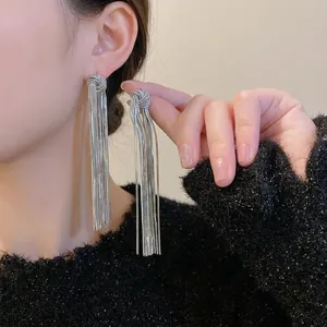 Silver long chain tassel earrings with geometric knots shown on model for a trendy look