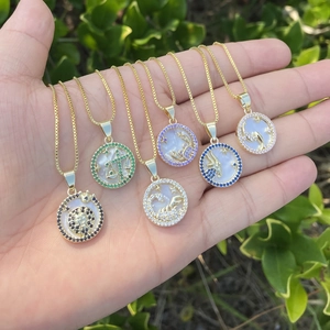 Detail of six 18K gold zodiac necklaces with colorful stones and shell inlay pendants