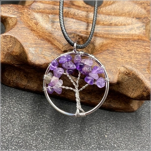 Macro shot of silver wire-wrapped tree of life pendant with purple amethyst stones