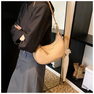 Dettaglio della borsa hobo beige a mezzaluna con trama in pelle e tracolla regolabile