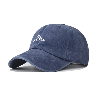 Detailed close-up of white mountain embroidery on washed navy cotton baseball cap