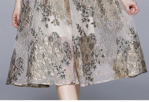 Nahaufnahme von champagner-goldenem Jacquard-Kleid mit floralem Muster und metallischem Glanz