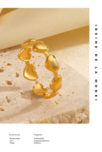 Detailed close-up of 18K gold plated heart chain ring on elegant silk stone display