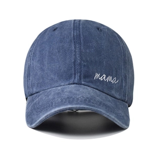 Close-up of white script mama embroidery on washed navy blue cotton baseball cap