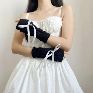 Japanese JK style black knit sleeves with white ribbon bows shown on model's hands