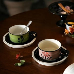 Detailed close-up of vintage ceramic coffee cups with hand-painted tulip and floral designs