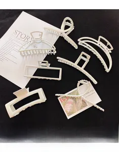 Detailed set of six white pearl-finish alloy claw clips in diverse geometric shapes