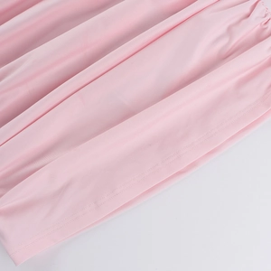 Close-up of pink fabric texture and fine stitching on the elegant long-sleeve dress