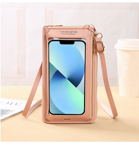 Pink touchscreen phone bag with transparent window and gold zippers on a home setting