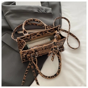 Dettaglio della trama leopardata e dei manici su una borsa a tracolla alla moda