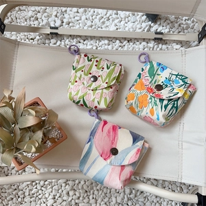 Close-up of portable floral fabric pouches with snap buttons and hanging rings