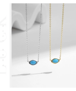 Detail of gold and silver S925 necklaces featuring oval turquoise pendants on stone