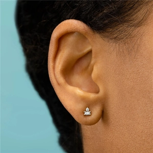 Detailed view of a gold-plated stud earring with baguette and round cut zirconia gems