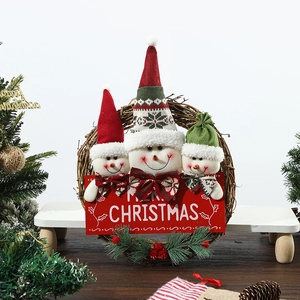 Close-up of a festive snowman family rattan wreath with merry christmas wooden sign