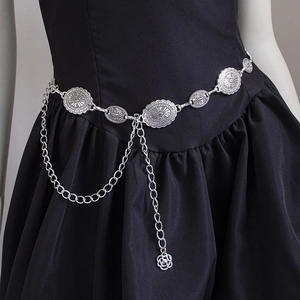 Vintage bohemian silver waist chain with embossed metal discs on a black dress