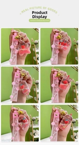Detail of strawberry oil liquid keychains with pink glitter, lucky wristband and bell