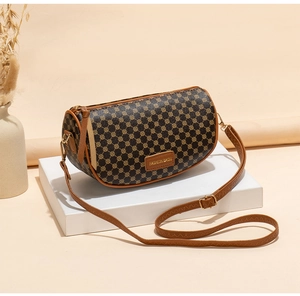 Detail of vintage brown geometric pattern crossbody cylinder bag with adjustable strap