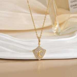 Elegant gold moon shield pendant necklace with sparkling cubic zirconia on a white background