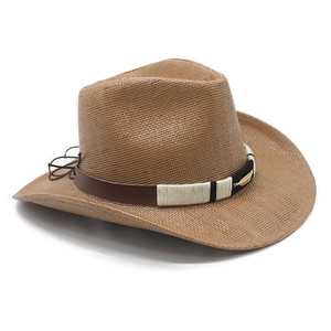 Macro detail of western straw hat with leather band and gold feather badge accent
