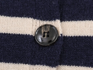 Macro detail of high-quality knit texture and marble button on striped cardigan
