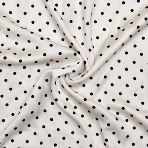 Vue macro détaillée du tissu à pois blancs et noirs avec une texture élégante et drapée