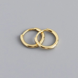 Detailed close-up of polished gold S925 sterling silver huggie hoop earrings