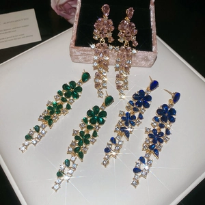Detail of floral tassel earrings with sparkling crystals in pink, green, and blue hues