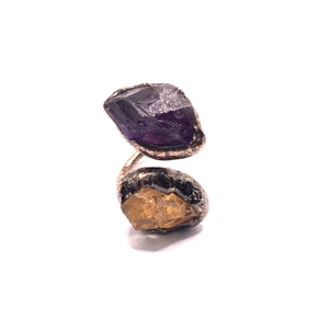 Macro view of adjustable copper ring with raw amethyst and citrine stones in metal bezel