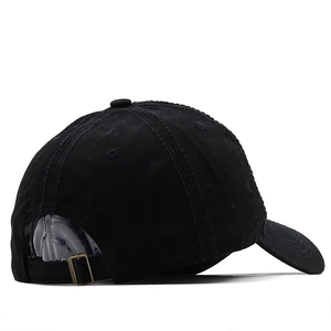 Detail view of the black washed cotton baseball cap featuring an adjustable bronze metal buckle