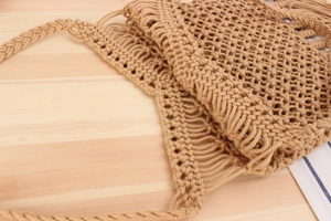 Detail of handmade woven hollow shoulder bag with fringe and wide braided strap