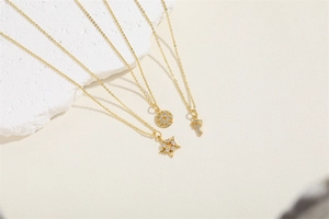 Elegant gold necklaces with star, sunburst and key pendants featuring white zircon stones