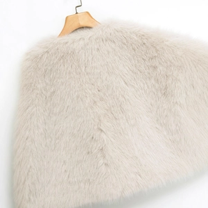 Gilet corto senza maniche in ecopelliccia beige da donna esposto su una gruccia in legno