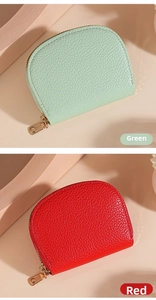 Detailed close-up of litchi texture leather card holders in green and red with gold zippers