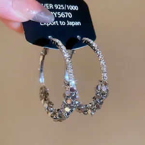 Sparkling geometric silver earrings with embedded crystals and faceted metallic finish