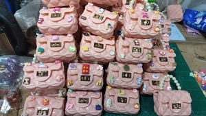 Detail view of pink quilted bags with cartoon charms and elegant pearl handles