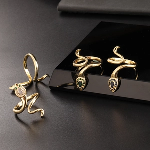 Detailed macro view of gold snake rings with vibrant gemstone heads and sparkling crystals