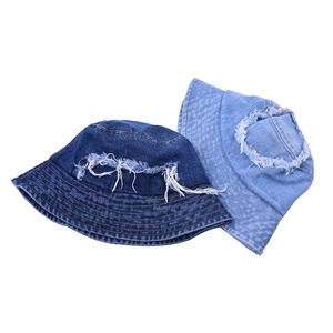 Distressed denim bucket hats in dark and light blue with frayed edges and ripped holes