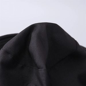 Dettaglio ravvicinato della trama in tessuto twill nero e delle cuciture del cappello