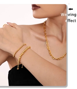 Model wearing gold 4mm bead bracelet and minimalist thick oval link chain necklace