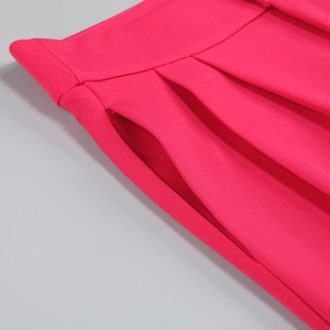 Close-up of side pockets and pleated waist details on rose red suit trousers